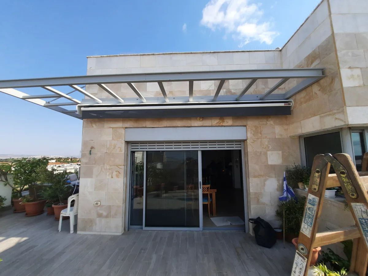 סוכך זרועות נפתח מעל חזית בית פרטי