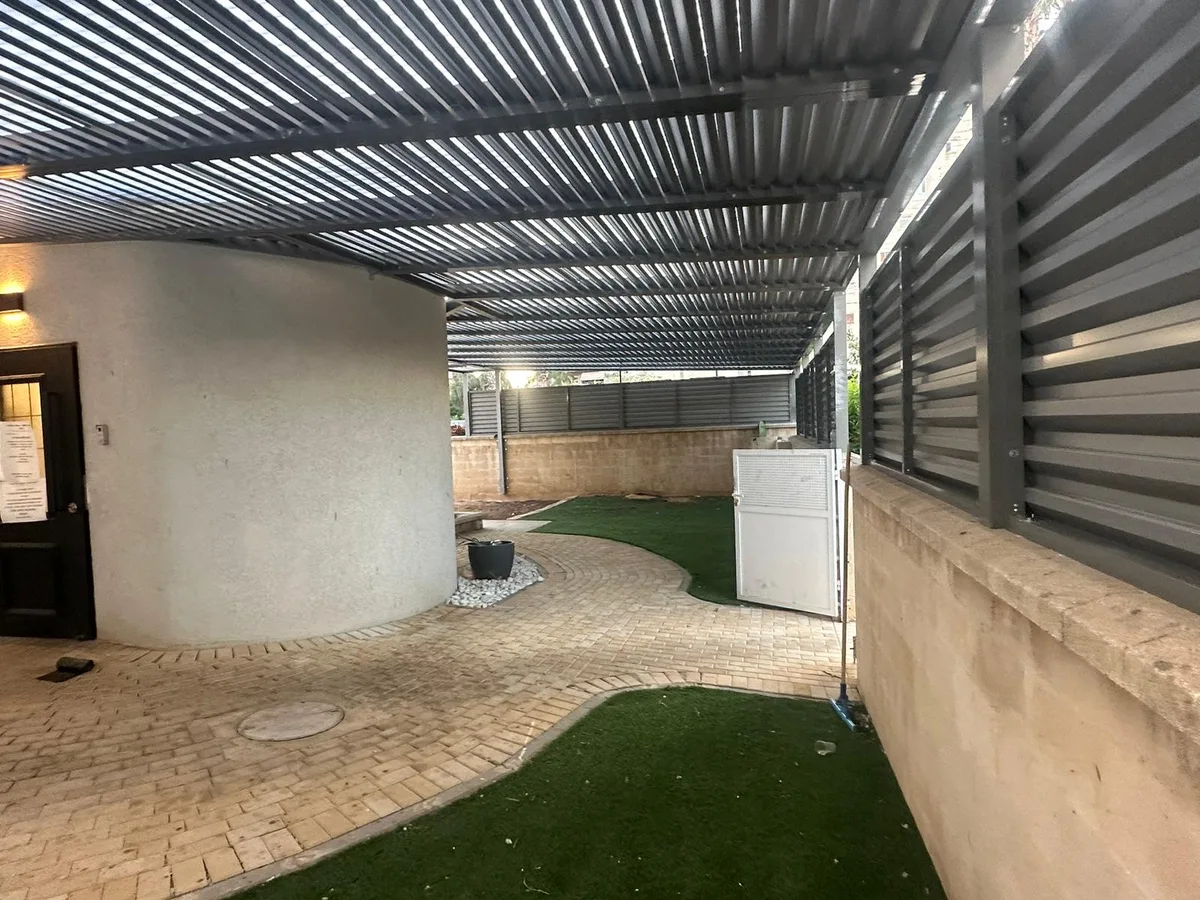 פרגולת אלומיניום מעל פינת ישיבה בגינה
