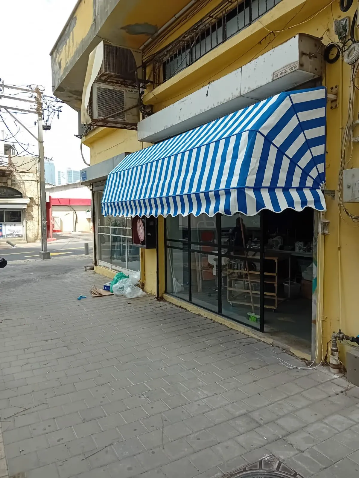 מרקיזה בפסים כחול-לבן מעל חזית עסק